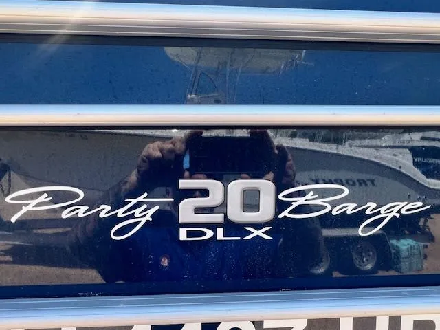 Slide: The Image of 2021 Sun Tracker Party Barge 20 DLX logo on boat exterior. - 20
