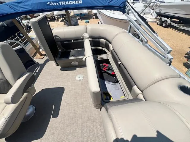 Slide: The Image of 2021 Sun Tracker Party Barge 20 DLX interior with open storage compartments and seating. - 7