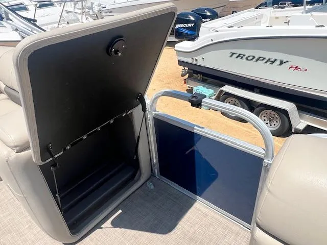 Slide: The Image of 2021 Sun Tracker Party Barge 20 DLX storage compartment and seating area. - 9