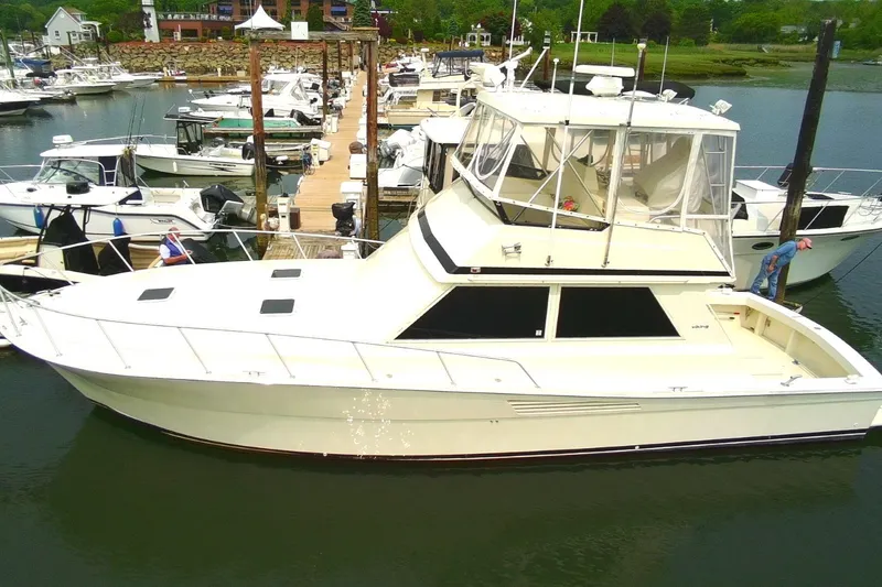 Slide: The Image of 1989 Viking 45 Convertible yacht docked at a marina, surrounded by other boats. - 0