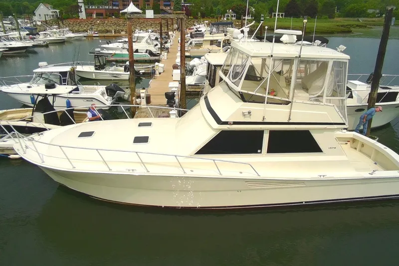 Slide: The Image of 1989 Viking 45 Convertible yacht docked at marina, surrounded by other boats. - 1