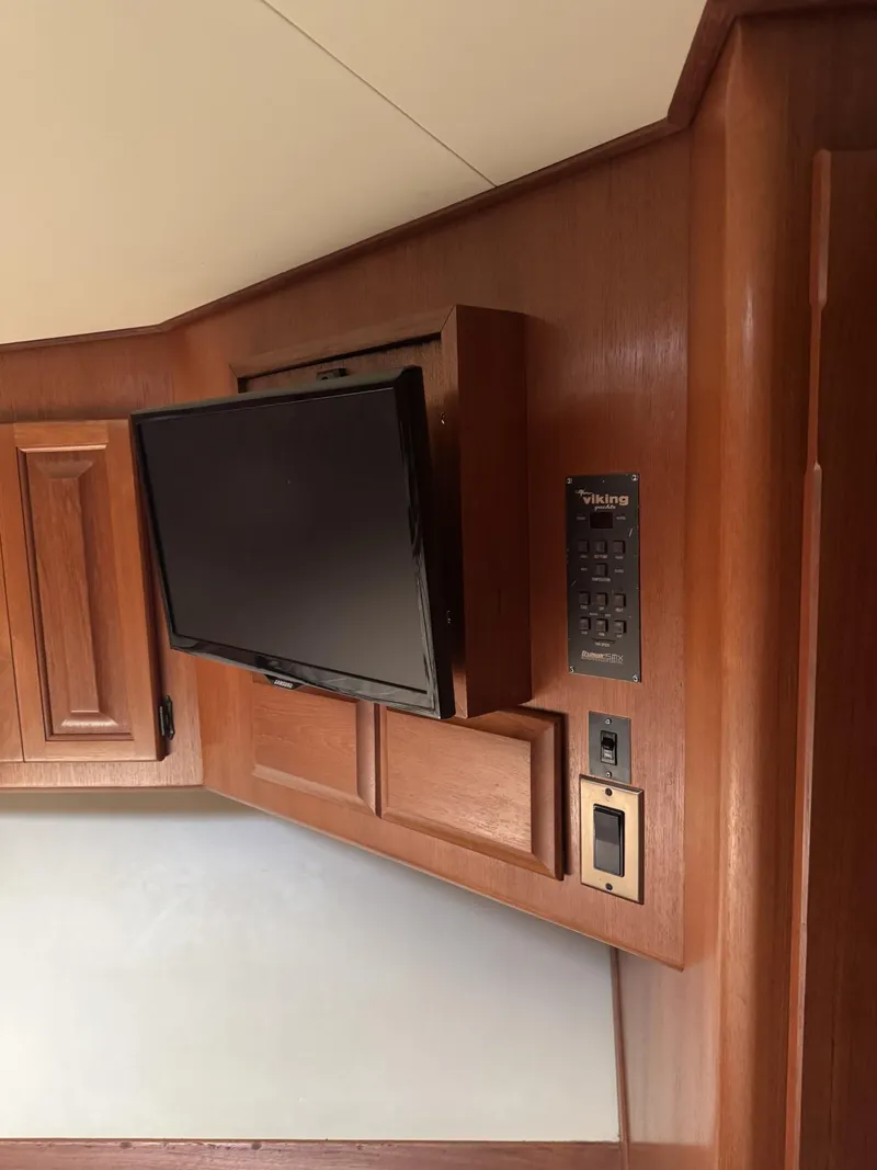 Slide: The Image of 1989 Viking 45 Convertible interior with mounted TV and wooden cabinetry. - 13