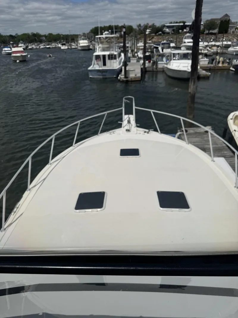 Slide: The Image of 1989 Viking 45 Convertible yacht docked in a marina, surrounded by other boats. - 27