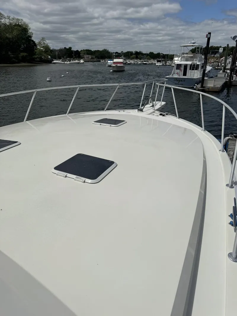 Slide: The Image of 1989 Viking 45 Convertible yacht on a calm river with other boats nearby. - 29