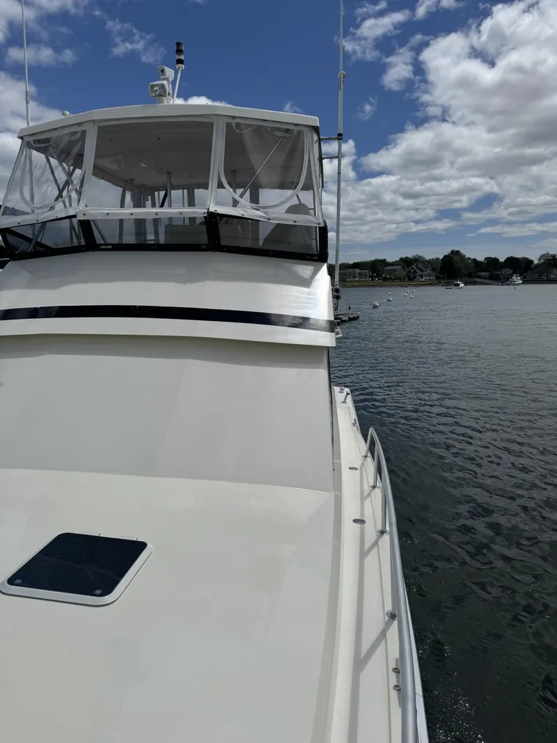 Slide: The Image of 1989 Viking 45 Convertible yacht on calm water under a partly cloudy sky. - 31