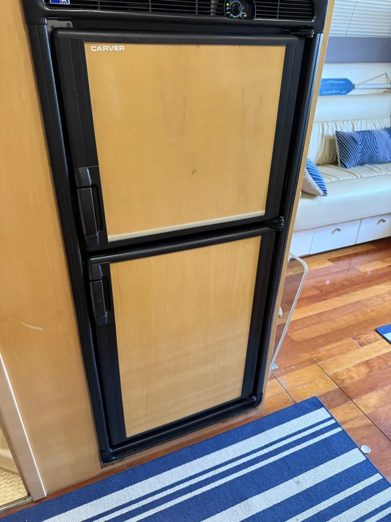 Slide: The Image of 2000 Carver 350 Mariner interior with wooden fridge and striped rug. - 24