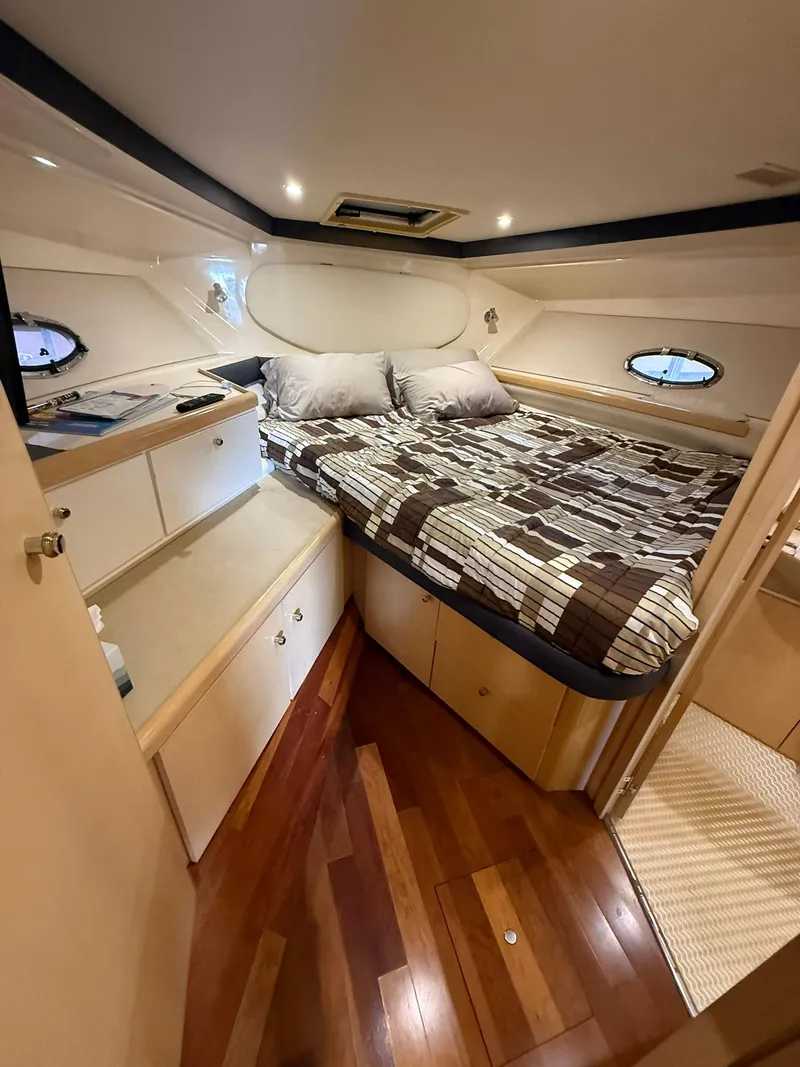 Slide: The Image of 2000 Carver 350 Mariner cabin with bed, wooden flooring, and storage cabinets. - 30