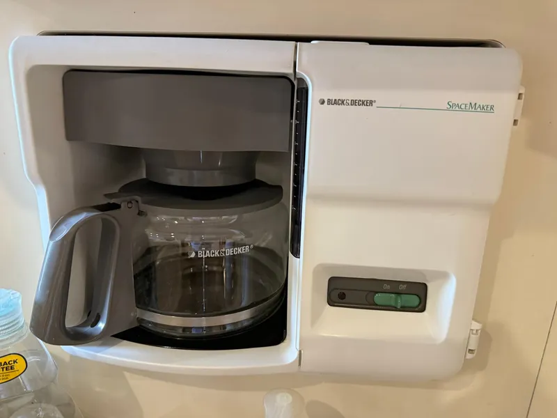 Slide: The Image of Black & Decker SpaceMaker coffee maker mounted on wall, featuring glass carafe and control buttons. - 27