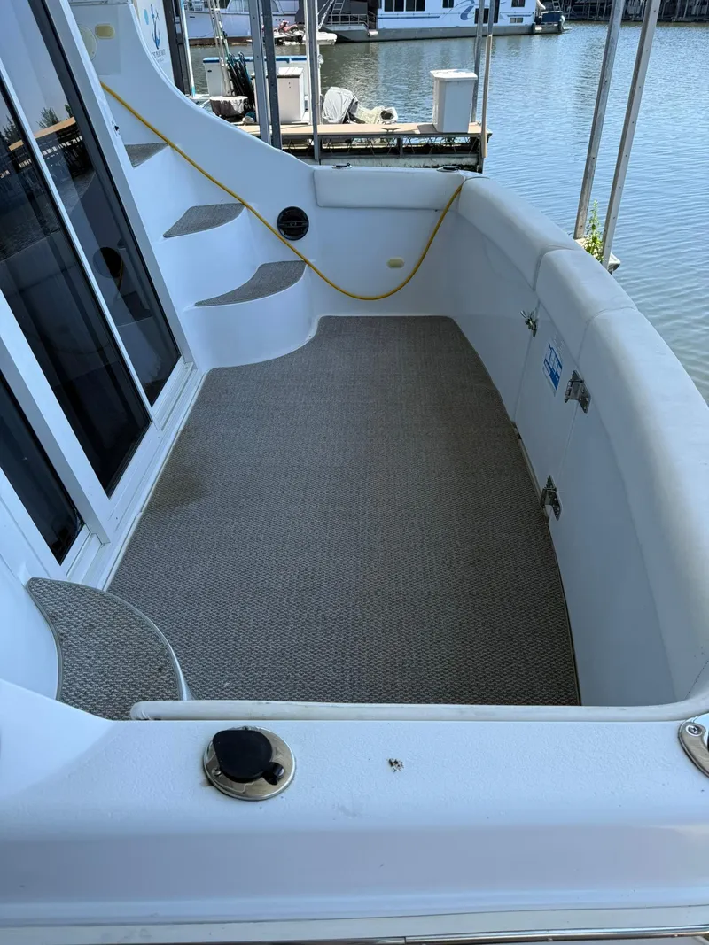 Slide: The Image of 2000 Carver 350 Mariner boat deck with carpet, docked by the water. - 4