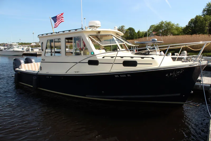 Slide: The Image of 2016 Eastern 27' Islander boat docked, featuring a sleek design and American flag. - 0