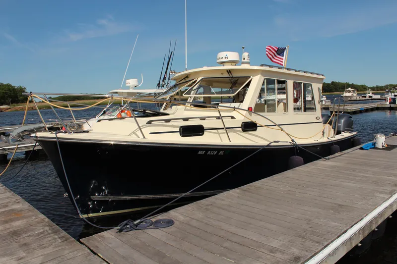 Slide: The Image of 2016 Eastern 27' Islander boat docked, featuring a sleek design and American flag. - 1