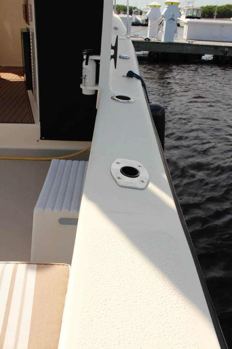 Slide: The Image of 2016 Eastern 27' Islander boat deck with rod holders, docked by the water. - 13
