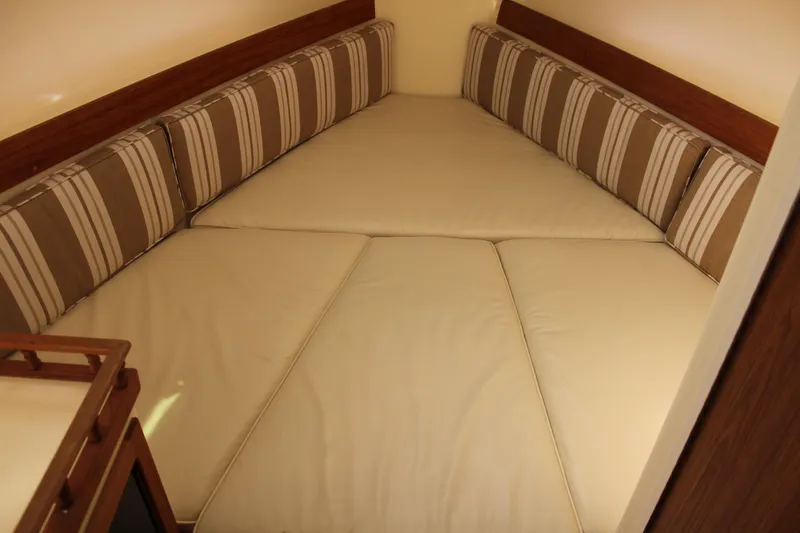 Slide: The Image of Interior cabin of 2016 Eastern 27' Islander with beige cushions and striped backrests. - 26