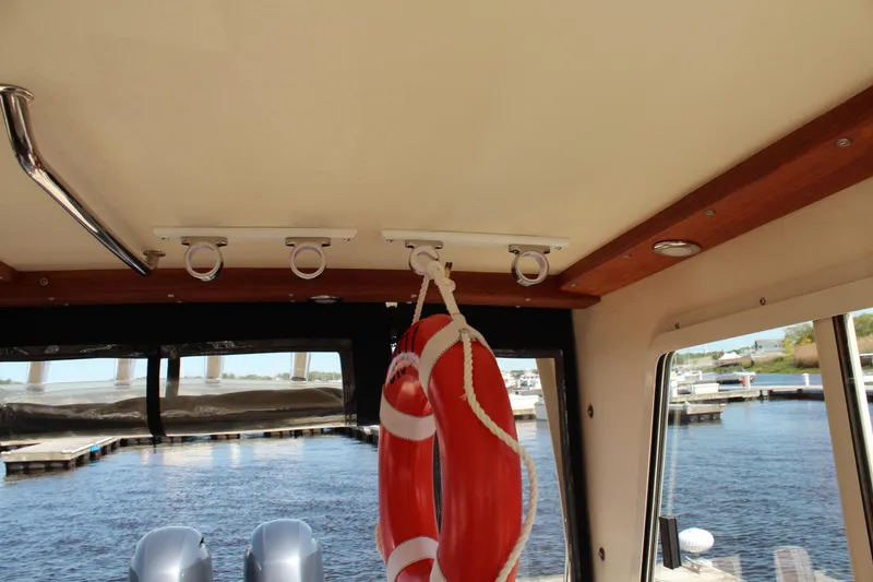 Slide: The Image of Interior view of 2016 Eastern 27' Islander boat with life preserver and marina background. - 30