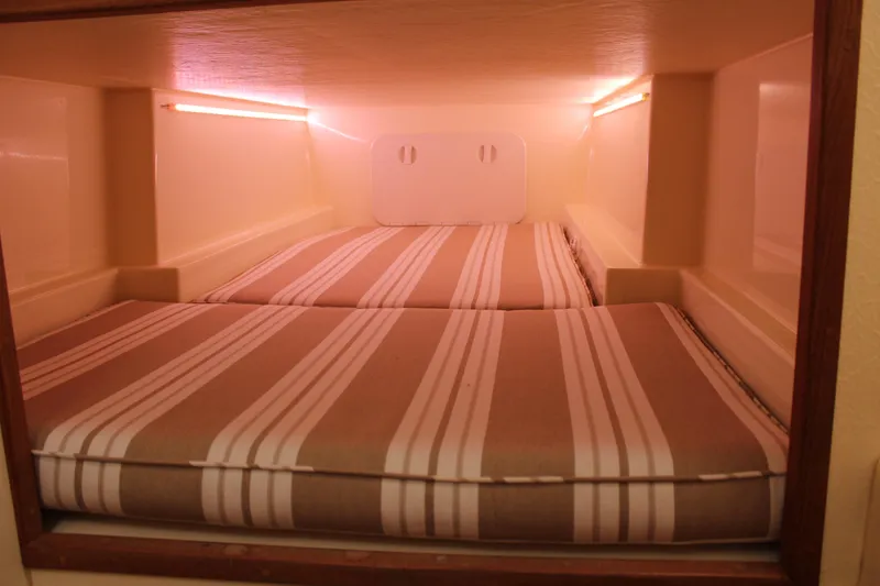 Slide: The Image of Cozy sleeping area in 2016 Eastern 27' Islander boat with striped cushions. - 36