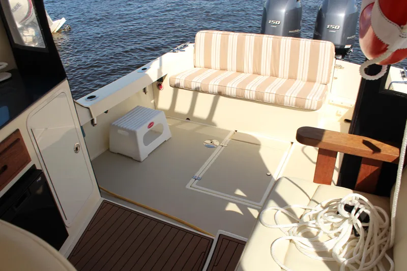 Slide: The Image of 2016 Eastern 27' Islander boat interior with striped seating and twin outboard motors. - 5