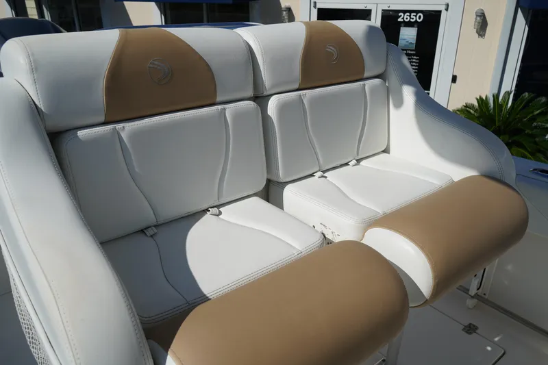 Slide: The Image of 2014 Edgewater 245CC boat seating, featuring white and tan cushioned seats. - 25