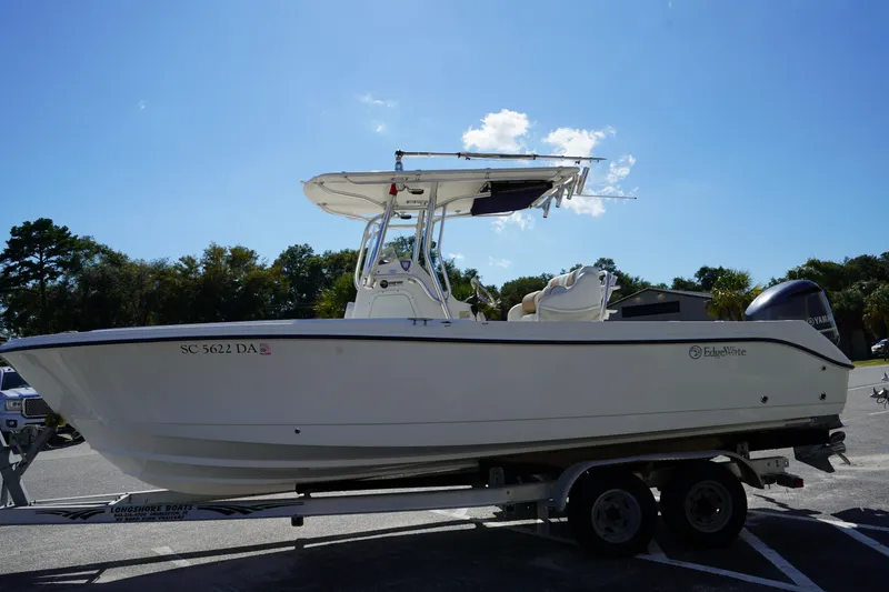 Slide: The Image of 2014 Edgewater 245CC boat on trailer under clear blue sky. - 4