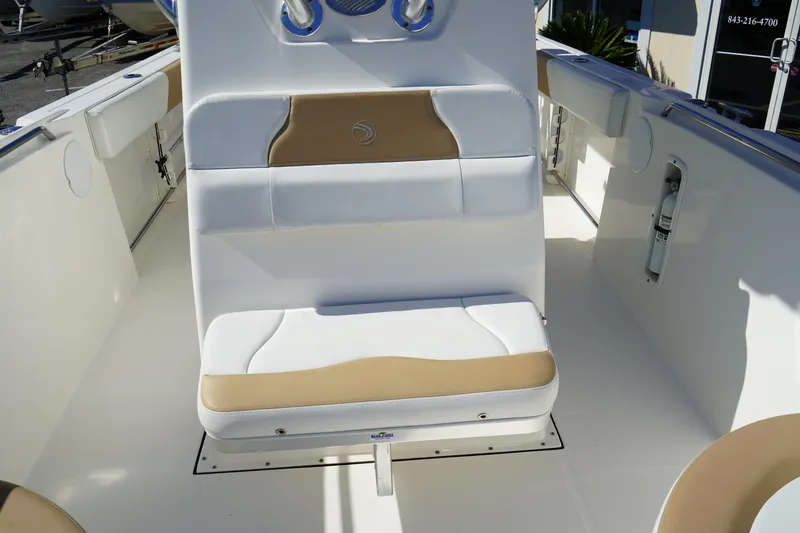 Slide: The Image of 2014 Edgewater 245CC boat interior with cushioned seating and white and tan upholstery. - 40