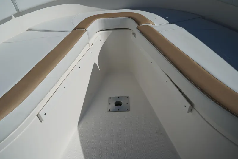 Slide: The Image of Interior view of 2014 Edgewater 245CC boat with tan and white seating. - 44