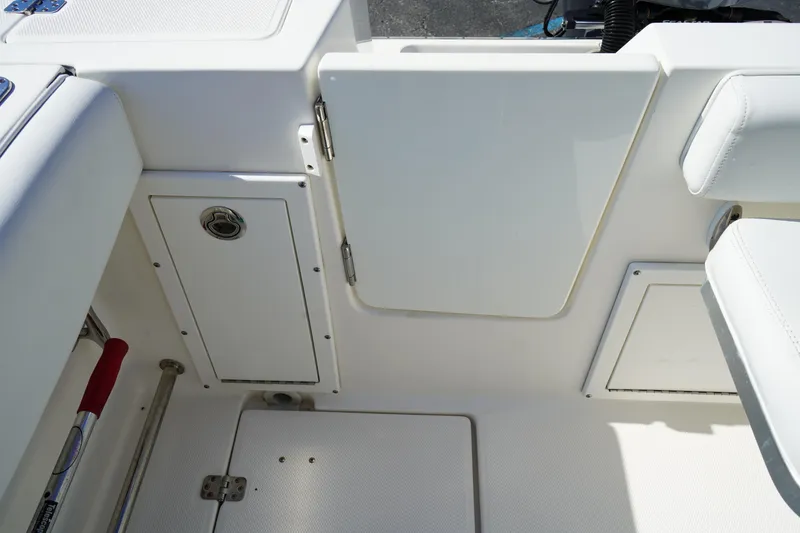 Slide: The Image of Interior view of a 2014 Edgewater 245CC boat, featuring storage compartments and seating. - 8
