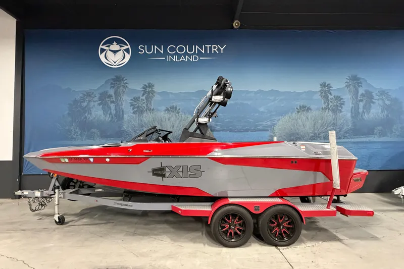 The Image of 2021 Axis A22 boat in red and gray on a trailer at Sun Country Inland showroom. - 0