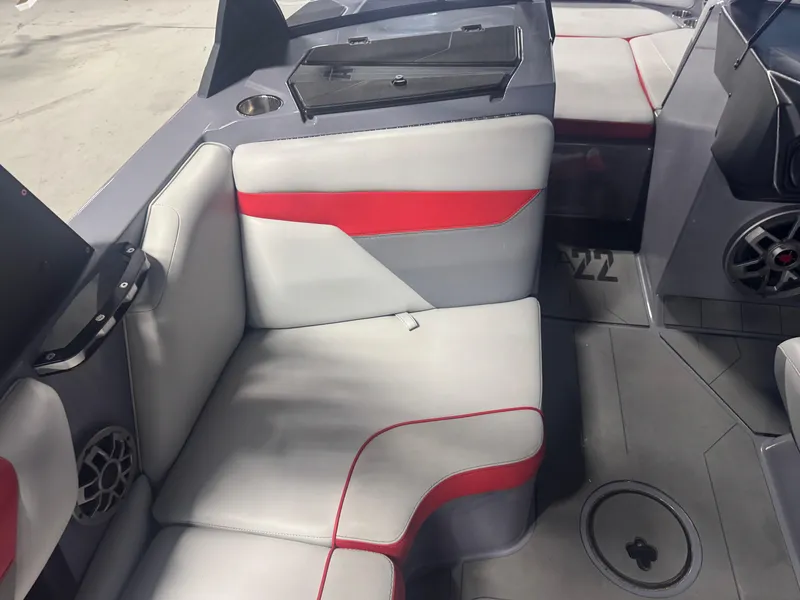 Slide: The Image of 2021 Axis A22 boat interior with gray and red seating, modern design, and speaker system. - 11