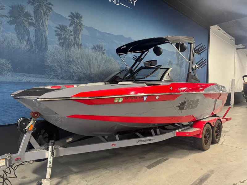 Slide: The Image of 2021 Axis A22 boat in showroom, red and gray design, on trailer. - 3