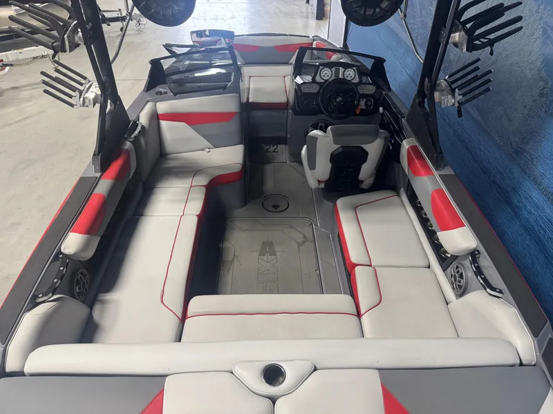 Slide: The Image of 2021 Axis A22 boat interior with red and gray seating, modern dashboard, and spacious layout. - 5