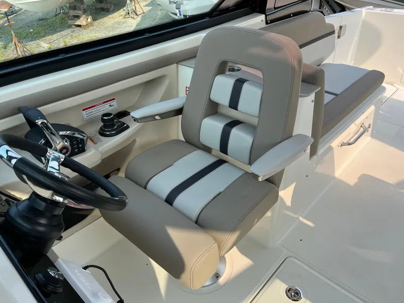 Slide: The Image of 2025 Boston Whaler 330 Vantage helm seat with beige and black upholstery. - 18