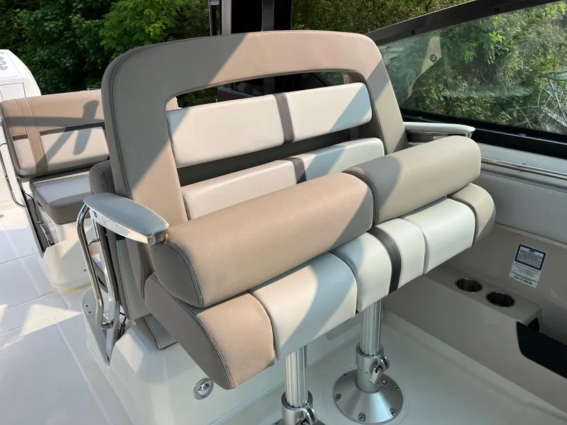 Slide: The Image of 2025 Boston Whaler 330 Vantage boat seating with beige and gray upholstery. - 19