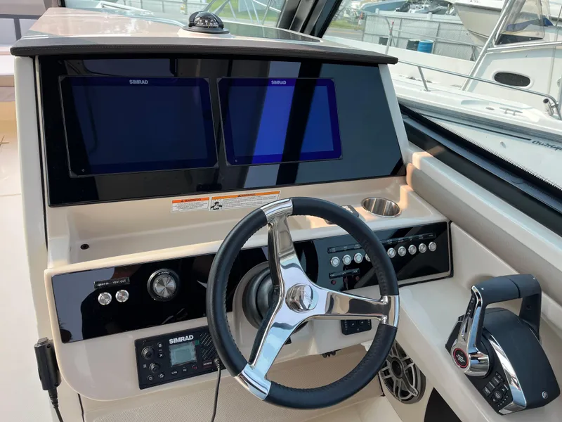 Slide: The Image of 2025 Boston Whaler 330 Vantage helm with dual screens and modern controls. - 2