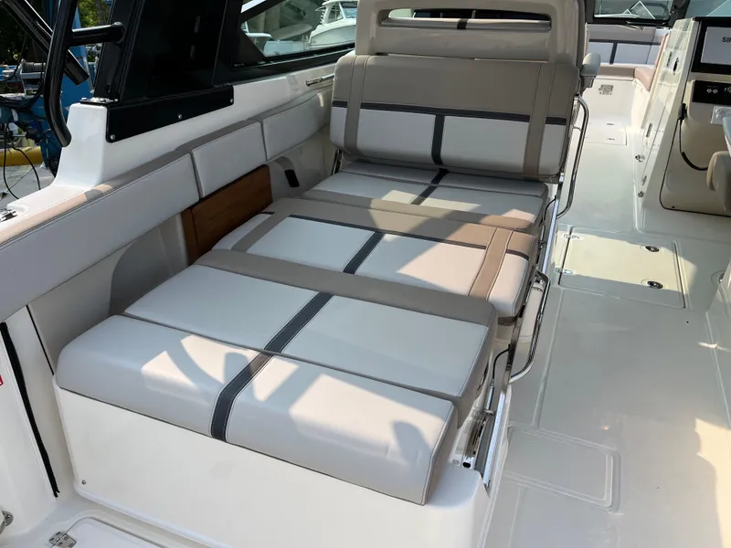Slide: The Image of 2025 Boston Whaler 330 Vantage interior seating with beige and gray upholstery. - 30