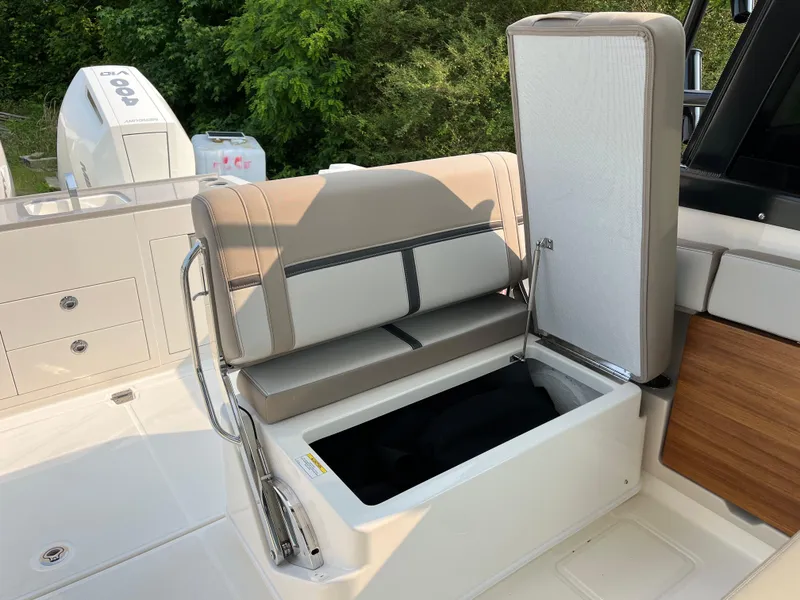 Slide: The Image of 2025 Boston Whaler 330 Vantage boat with open storage compartment and cushioned seating. - 31
