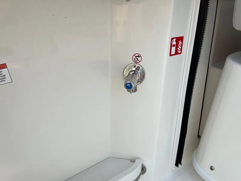 Slide: The Image of 2025 Boston Whaler 330 Vantage interior detail with safety signage and control knob. - 37