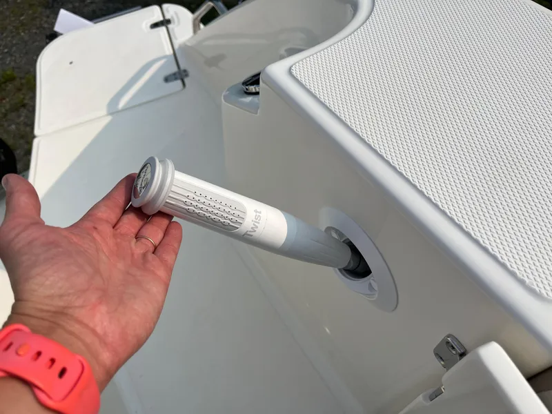 Slide: The Image of Hand adjusting a feature on a 2025 Boston Whaler 330 Vantage boat. - 38