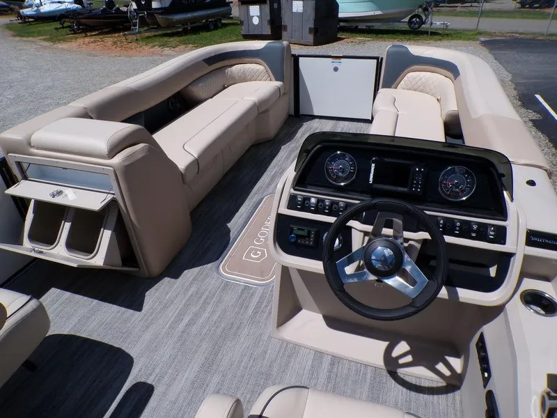 Slide: The Image of 2025 Godfrey Sweetwater 2286 SB boat interior with plush seating and modern dashboard. - 9