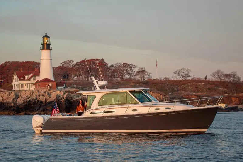 The Image of 2026 Back Cove 39O boat cruising near a lighthouse at sunset. - 0