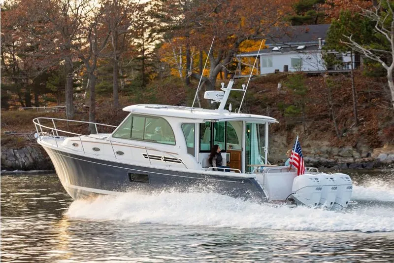 Slide: The Image of 2026 Back Cove 39O cruising on a scenic waterway with autumn foliage. - 2