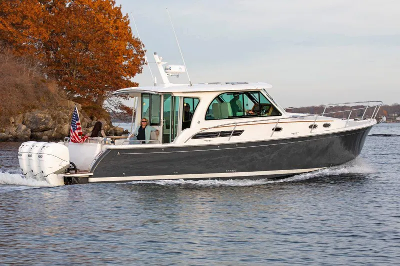 Slide: The Image of 2026 Back Cove 39O boat cruising on a calm lake with autumn trees in the background. - 3