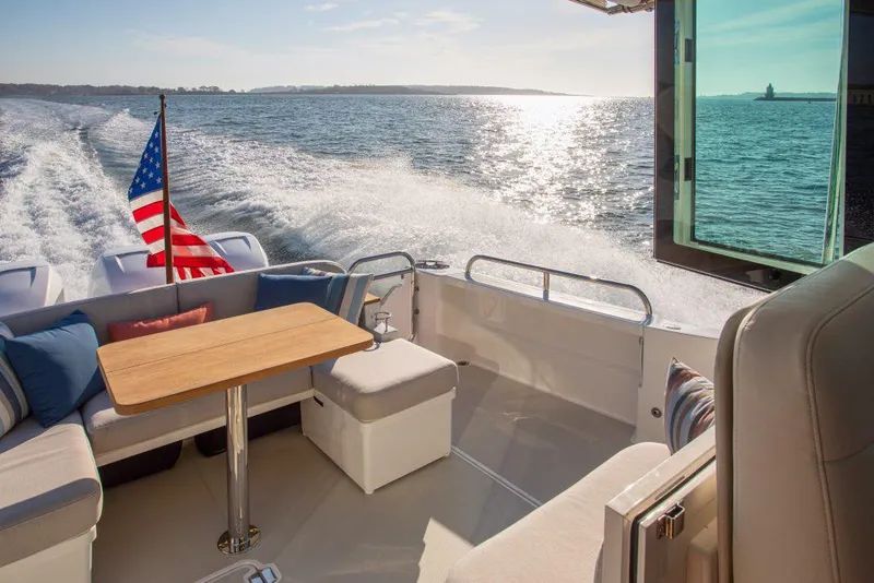 Slide: The Image of Back Cove 39O 2026 yacht cruising with American flag, sunlit ocean view. - 6
