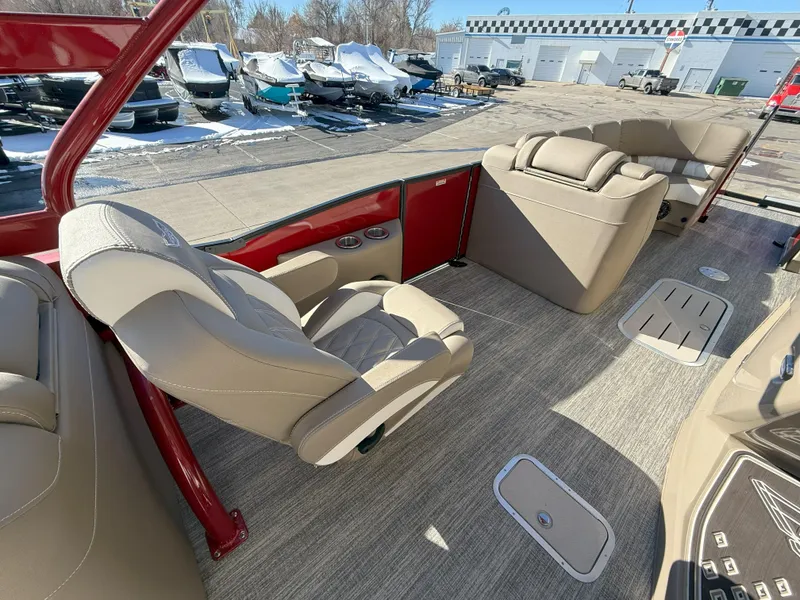 Slide: The Image of Luxurious interior of 2025 Bennington 25QXFB boat with beige seating and red accents. - 13
