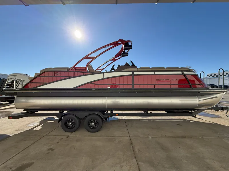 Slide: The Image of 2025 Bennington 25QXFB pontoon boat on trailer under clear blue sky. - 4