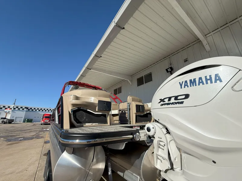 Slide: The Image of 2025 Bennington 25QXFB boat with Yamaha XTO Offshore engine, docked under a metal roof. - 5