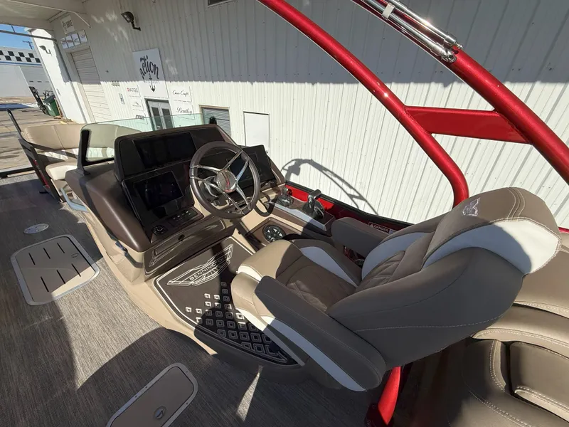 Slide: The Image of 2025 Bennington 25QXFB boat interior with modern helm and comfortable seating. - 7