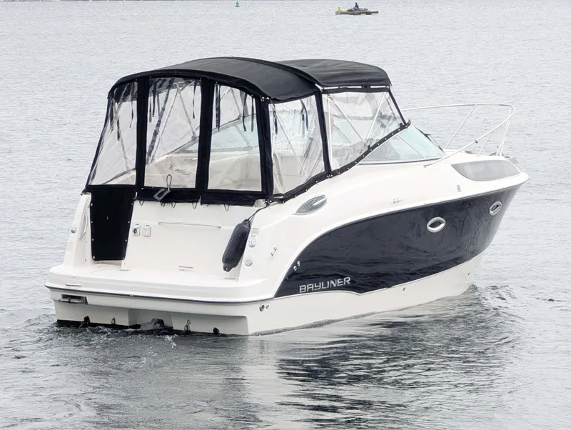 Slide: The Image of 2010 Bayliner 255 SB boat with black canopy cruising on calm water. - 1