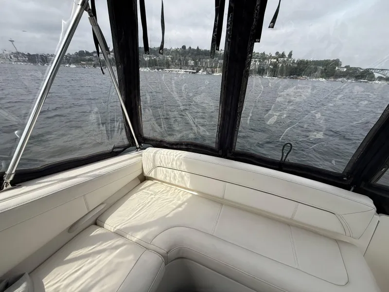 Slide: The Image of Interior view of 2010 Bayliner 255 SB boat with white seating and water backdrop. - 11