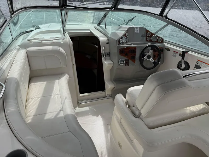 Slide: The Image of Interior of 2010 Bayliner 255 SB boat with white seating and steering console. - 12