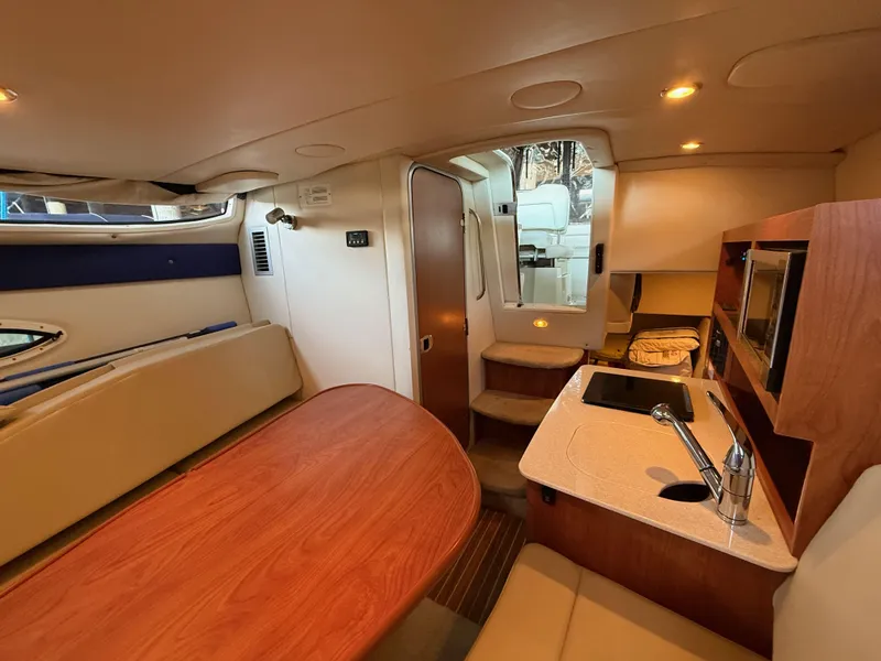 Slide: The Image of Interior of 2010 Bayliner 255 SB boat with kitchenette and seating area. - 17