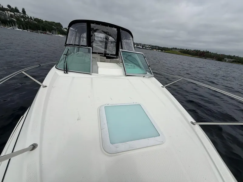 Slide: The Image of 2010 Bayliner 255 SB boat on water, featuring open deck and cabin entrance. - 24
